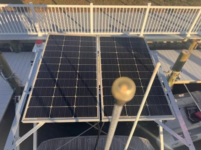 Slide: The Image of Solar panels on a 2016 Beneteau Swift Trawler 30, docked near a white fence. - 11