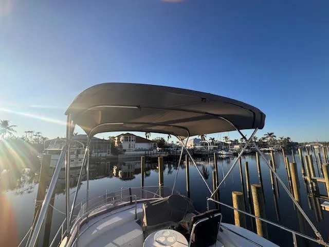 Slide: The Image of 2016 Beneteau Swift Trawler 30 docked, featuring a canopy under a clear blue sky. - 24