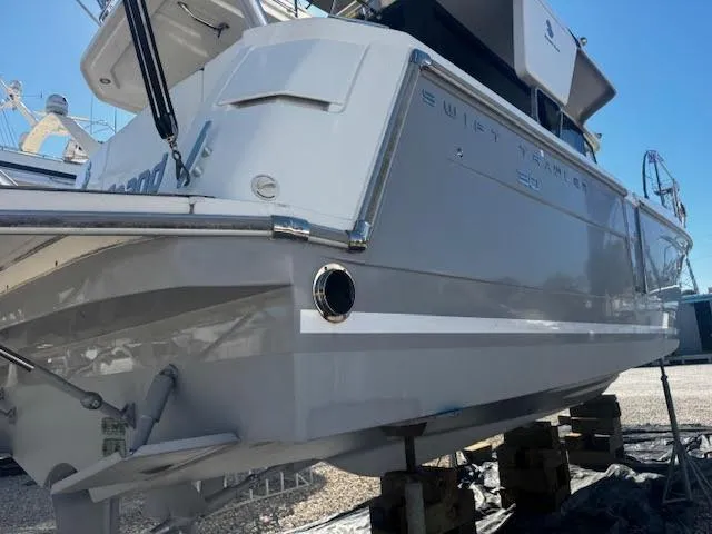 Slide: The Image of 2016 Beneteau Swift Trawler 30 on blocks, rear view, in a boatyard. - 25