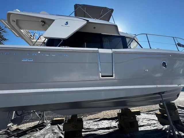Slide: The Image of 2016 Beneteau Swift Trawler 30 on blocks, side view under clear blue sky. - 29
