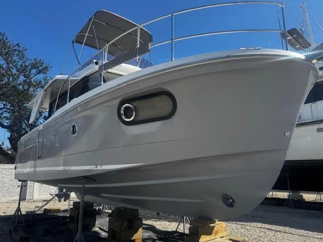 Slide: The Image of 2016 Beneteau Swift Trawler 30 on stands, side view, clear sky background. - 33