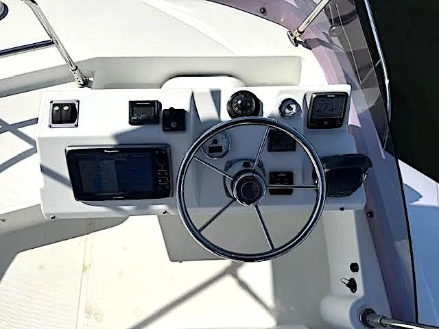 Slide: The Image of 2016 Beneteau Swift Trawler 30 helm with steering wheel and navigation controls. - 40