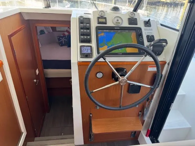 Slide: The Image of 2016 Beneteau Swift Trawler 30 helm with navigation system and cozy cabin view. - 42