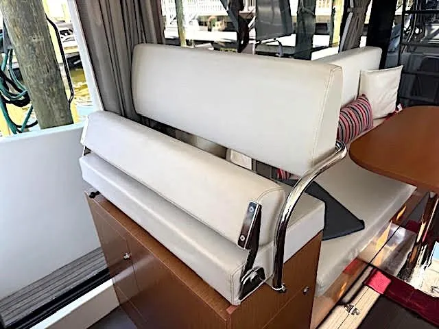 Slide: The Image of Interior seating of 2016 Beneteau Swift Trawler 30 with white cushions and wooden accents. - 43