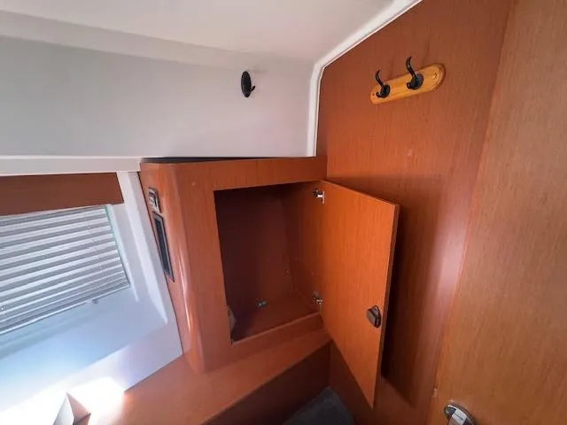 Slide: The Image of Interior cabin of 2016 Beneteau Swift Trawler 30 with wooden storage and hooks. - 5