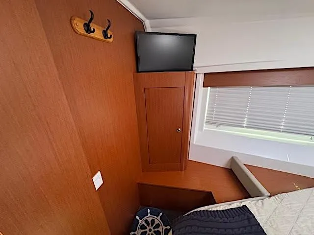 Slide: The Image of Interior cabin of 2016 Beneteau Swift Trawler 30 with TV and wooden cabinetry. - 6
