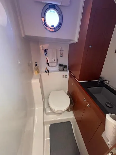 Slide: The Image of 2016 Beneteau Swift Trawler 30 bathroom with porthole, sink, and storage. - 9