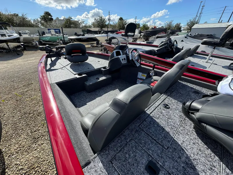 Slide: The Image of 2025 Tracker Pro Team 175 boat with gray interior and red trim, parked outdoors. - 3
