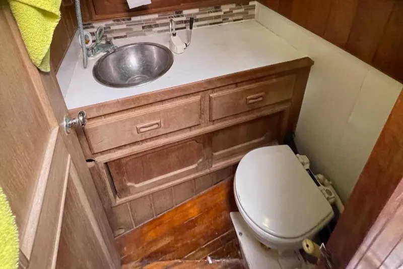 Slide: The Image of 1979 C & L Explorer Center Cockpit Cutter bathroom with wooden cabinetry and compact sink. - 18