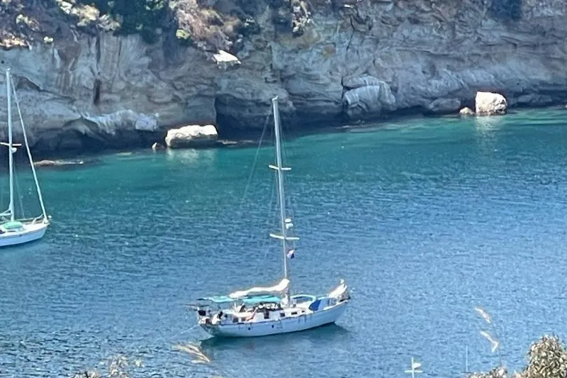 Slide: The Image of A 1979 C & L Explorer Center Cockpit Cutter anchored in a serene coastal bay. - 21