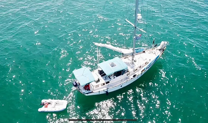 Slide: The Image of Aerial view of 1979 C & L Explorer Center Cockpit Cutter sailboat on sparkling ocean water. - 24
