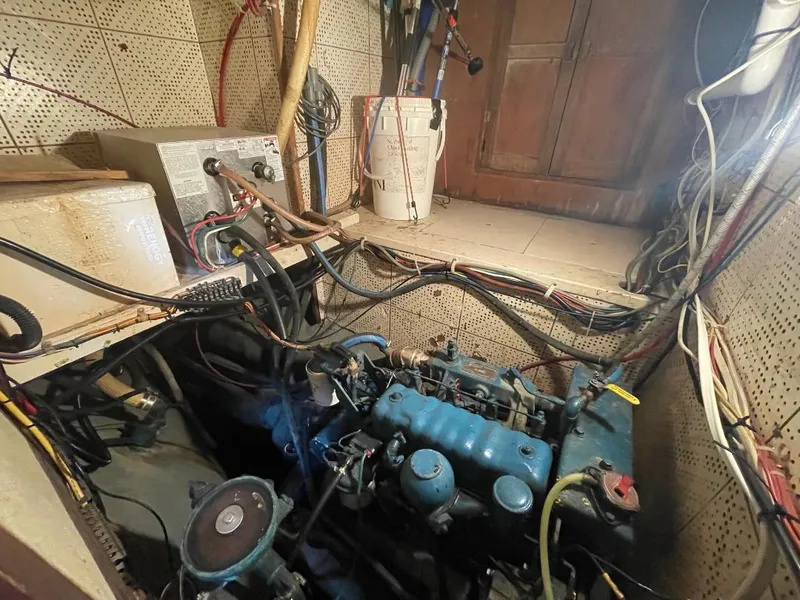 Slide: The Image of Engine room of a 1979 C & L Explorer Center Cockpit Cutter with visible wiring and components. - 25