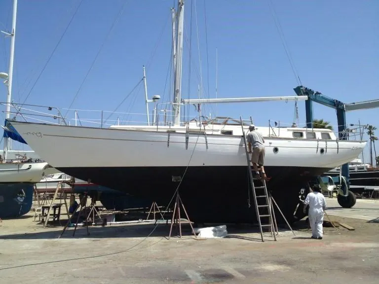 Slide: The Image of 1979 C & L Explorer Center Cockpit Cutter sailboat on dry dock with maintenance crew. - 7