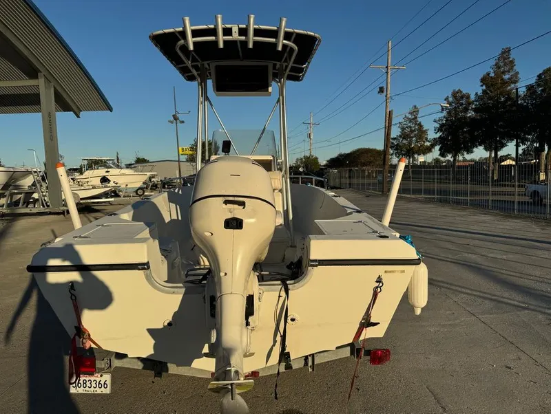 Slide: The Image of 2004 Sea Boss 190 Center Console boat with outboard motor, parked outdoors. - 7