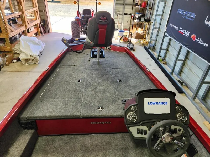 Slide: The Image of 2025 Ranger RT188 boat interior with Lowrance system, red and gray seating, in a garage. - 7