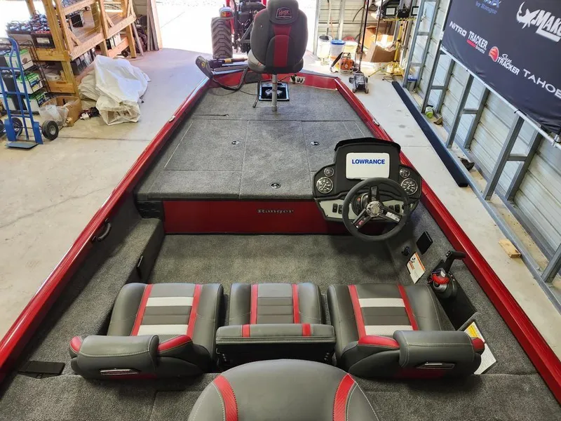Slide: The Image of 2025 Ranger RT188 boat interior with Lowrance electronics, red and gray seating, in a garage setting. - 8