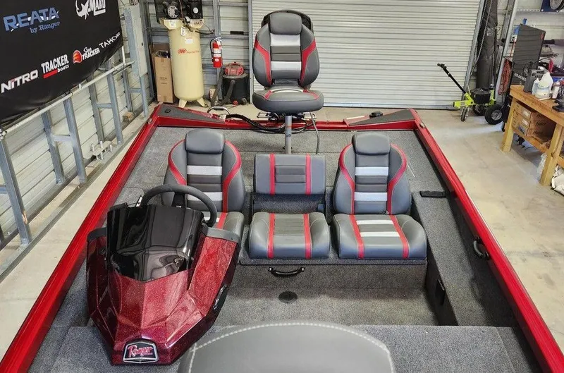 Slide: The Image of 2025 Ranger RT188 boat interior with red and gray seating in a garage setting. - 9
