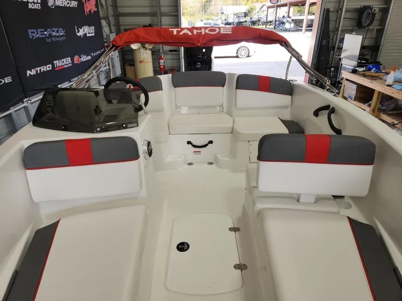 Slide: The Image of 2025 Tahoe T16 boat interior with red and gray seating, steering wheel, and canopy. - 8