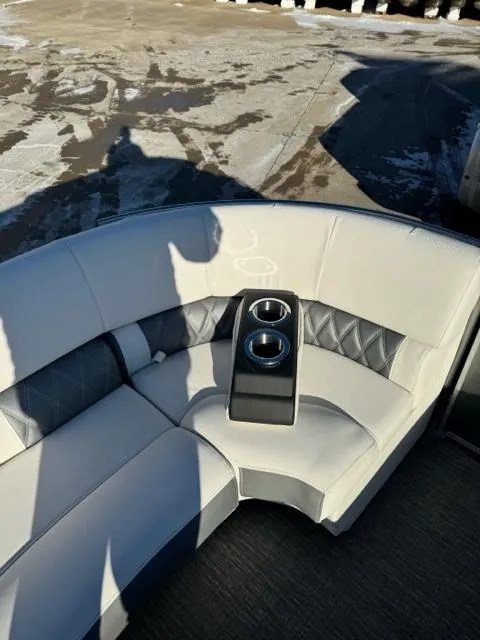 Slide: The Image of 2024 Bennington 25 QFB boat interior with cushioned seating and cup holders. - 14