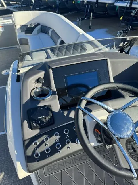 Slide: The Image of 2024 Bennington 25 QFB boat dashboard with steering wheel and control panel. - 17