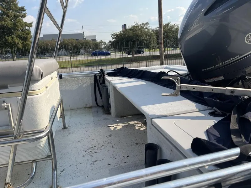 Slide: The Image of 2002 Champion 230-RV boat with outboard motor and console, docked under a canopy. - 8