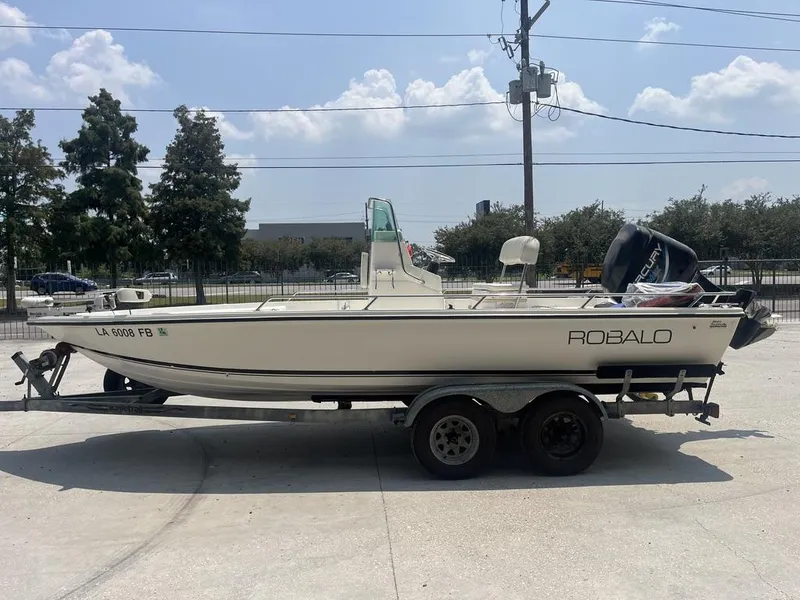 Slide: The Image of 2000 Robalo boat on trailer, parked outdoors under a clear sky. - 1
