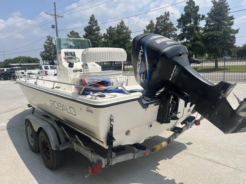 Slide: The Image of 2000 Robalo boat on trailer with Mercury outboard motor, parked outdoors. - 11