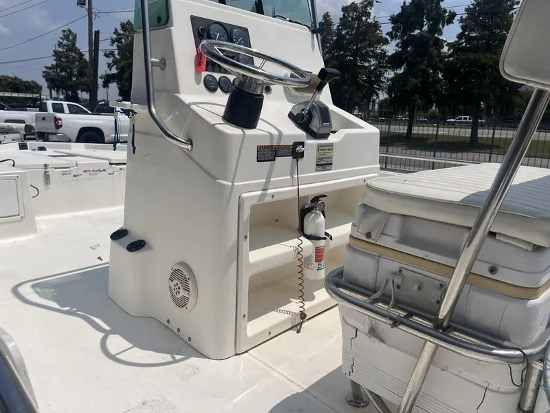 Slide: The Image of 2000 Robalo boat console with steering wheel, controls, and fire extinguisher on deck. - 3
