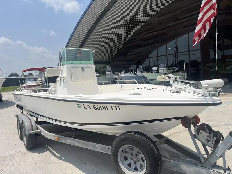Slide: The Image of 2000 Robalo boat on trailer, parked outside with American flag in background. - 8