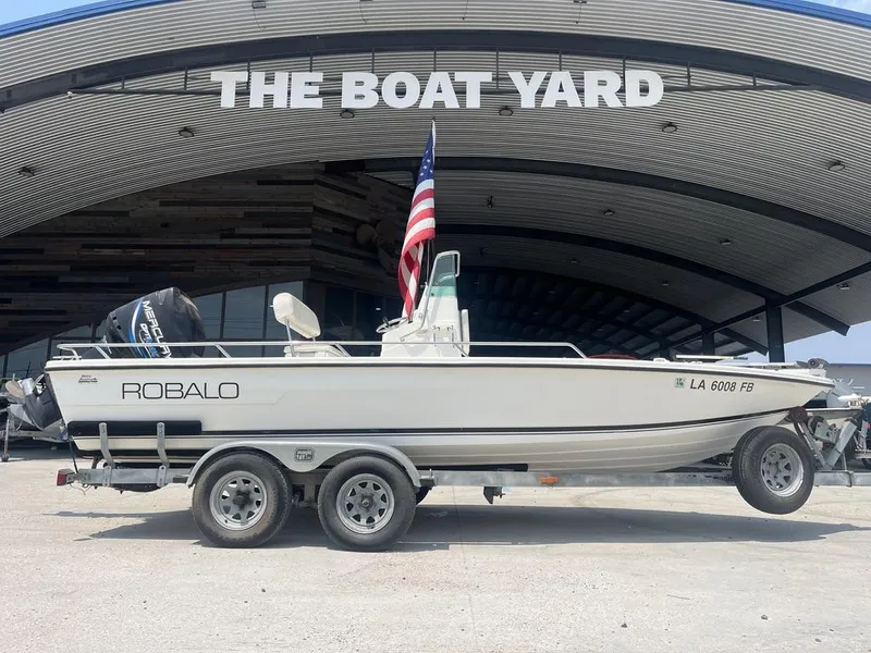 Slide: The Image of 2000 Robalo boat on trailer at The Boat Yard, featuring American flag. - 9