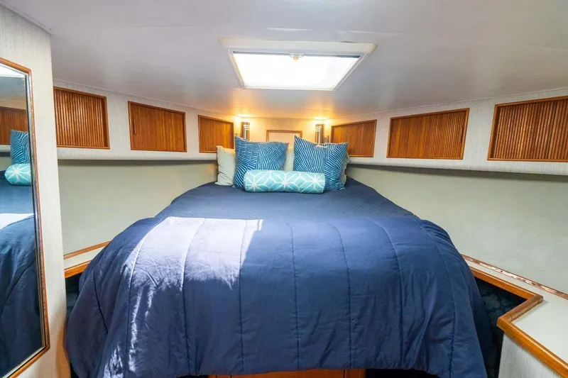 Slide: The Image of Cozy cabin interior of 1993 Buddy Davis Express Custom Carolina with blue bedding and wooden accents. - 10