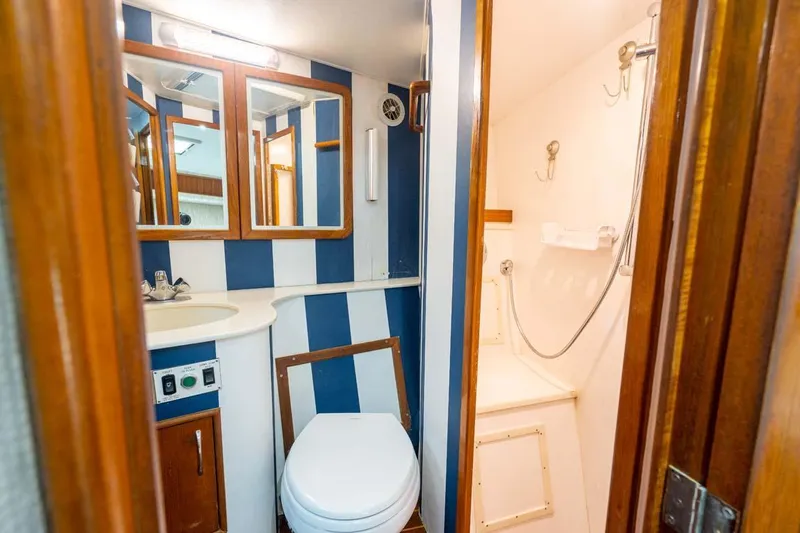 Slide: The Image of Bathroom interior of 1993 Buddy Davis Express Custom Carolina boat, featuring striped walls and compact design. - 11