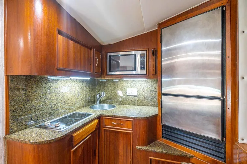Slide: The Image of Luxurious 1993 Buddy Davis Express Custom Carolina yacht kitchen with wood cabinetry and modern appliances. - 8