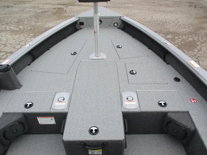 Slide: The Image of 2025 Lund Pro Guide 1875 boat interior with storage compartments and gray carpeting. - 13