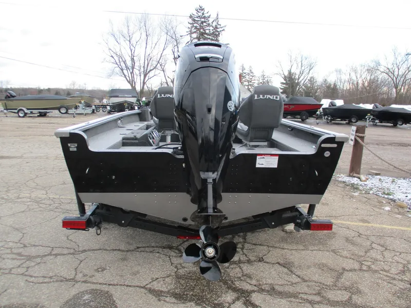 Slide: The Image of 2025 Lund Pro Guide 1875 boat, rear view with motor, parked on a trailer. - 3