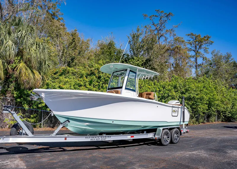 Slide: The Image of 2025 Sea Hunt Ultra 255 SE boat on trailer, surrounded by lush greenery. - 1