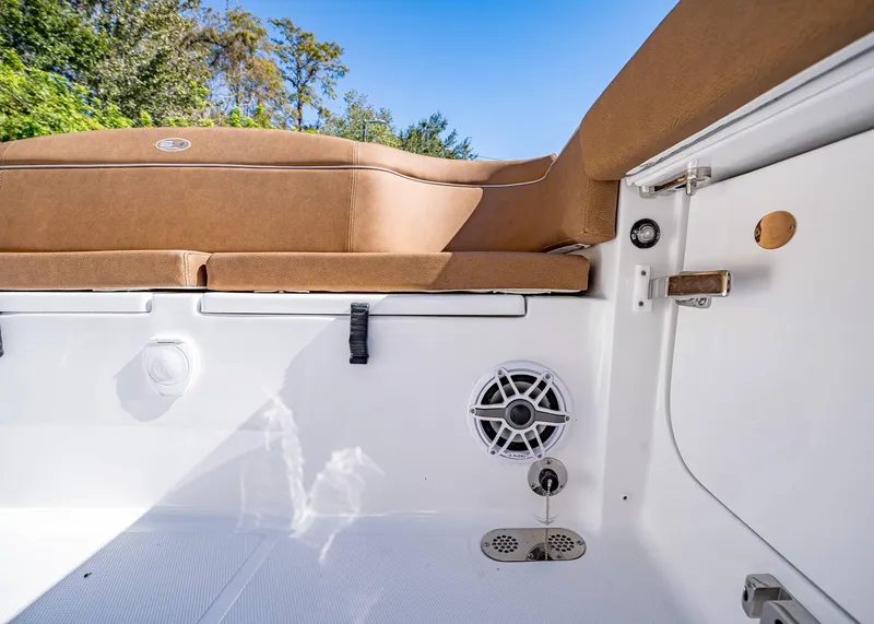 Slide: The Image of 2025 Sea Hunt Ultra 255 SE boat interior with tan seating and speaker system. - 10