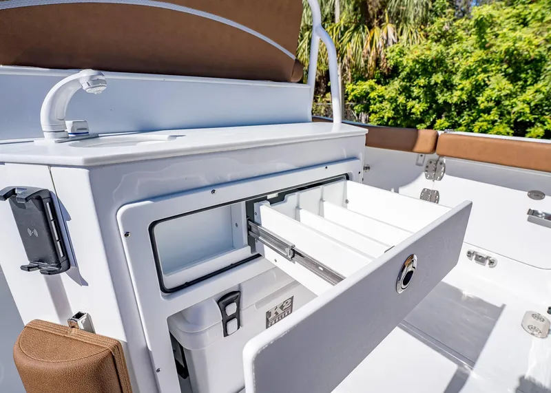 Slide: The Image of 2025 Sea Hunt Ultra 255 SE boat interior with open storage drawer and faucet. - 18