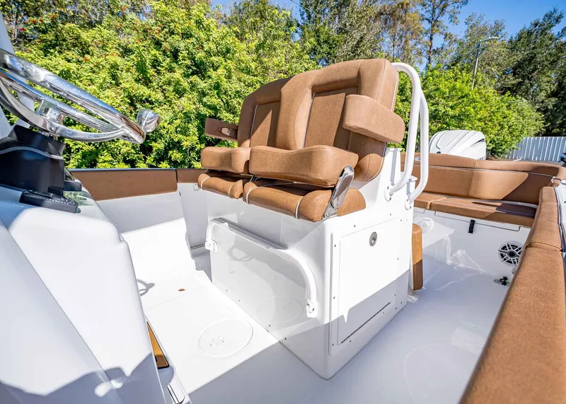 Slide: The Image of 2025 Sea Hunt Ultra 255 SE boat interior with brown seating and steering wheel. - 24