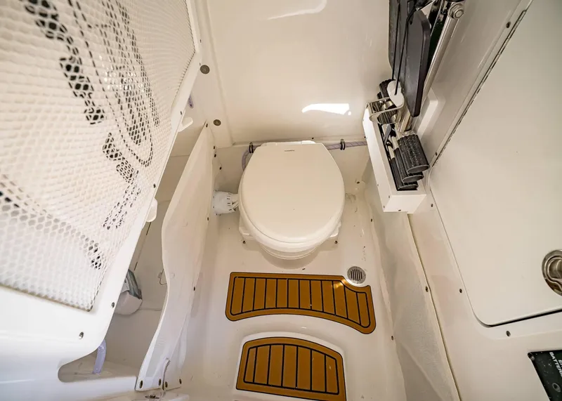 Slide: The Image of 2025 Sea Hunt Ultra 255 SE boat interior with compact marine toilet. - 36