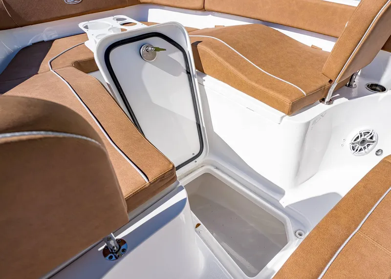 Slide: The Image of 2025 Sea Hunt Ultra 255 SE boat interior with tan seating and storage compartment. - 40