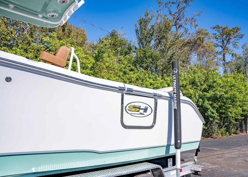 Slide: The Image of 2025 Sea Hunt Ultra 255 SE boat on trailer, surrounded by trees. - 5