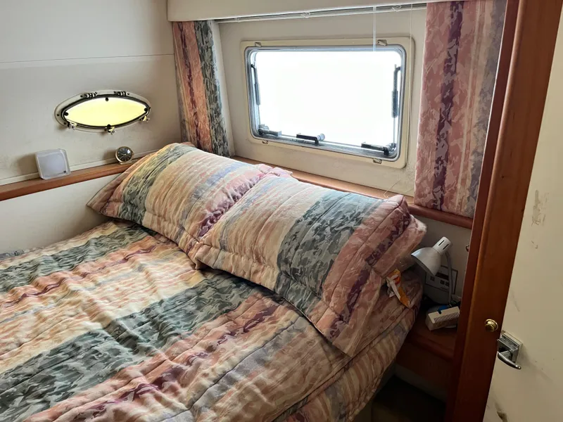 Slide: The Image of Cozy bedroom in 1998 Silverton 322 Motor Yacht with patterned bedding and window view. - 13