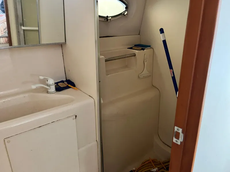 Slide: The Image of 1998 Silverton 322 Motor Yacht bathroom with sink, mirror, and shower area. - 15