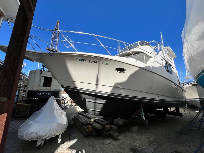 Slide: The Image of 1998 Silverton 322 Motor Yacht in dry dock, side view under clear blue sky. - 4