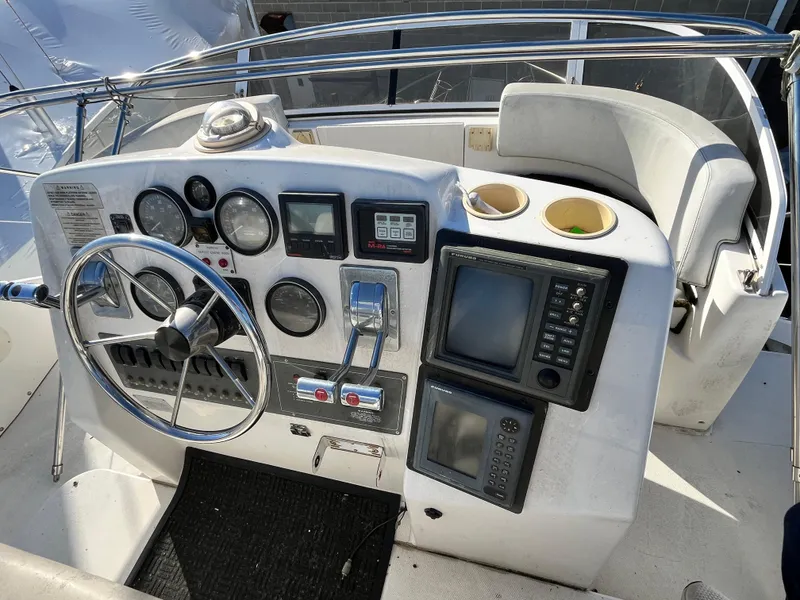 Slide: The Image of 1998 Silverton 322 Motor Yacht helm with steering wheel, gauges, and navigation equipment. - 6