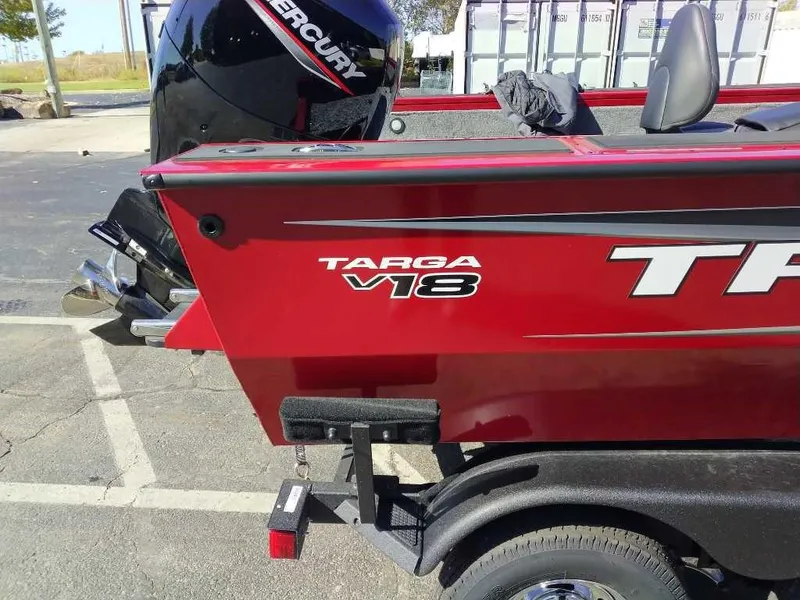 Slide: The Image of 2025 Tracker Targa V-18 WT boat, red exterior, parked with Mercury engine. - 5