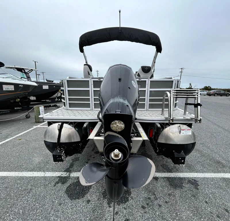 Slide: The Image of 2024 Berkshire 24RFC LE 2.75 pontoon boat with outboard motor in parking lot. - 17