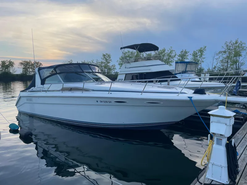 The Image of 1992 Sea Ray 370 Sundancer docked at sunset, calm waters, nearby boats. - 1