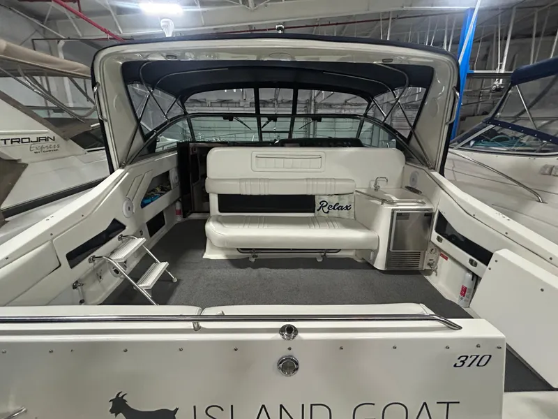 Slide: The Image of 1992 Sea Ray 370 Sundancer boat interior with seating and canopy in a marina. - 17